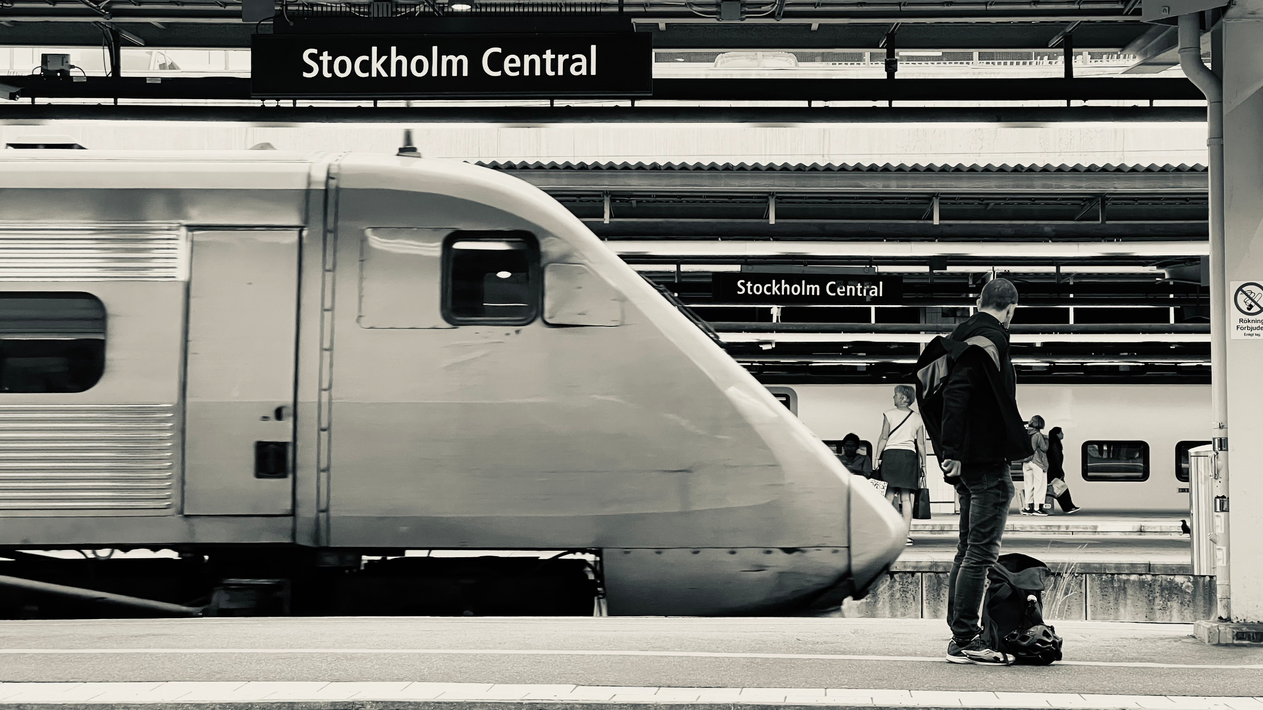 Trein leaving the station with people watching on platform